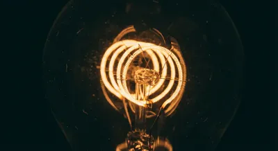 Gros plan macro sur le filament d'une ampoule électrique sous-alimentée.